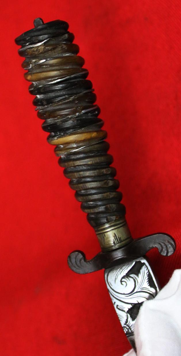 Italian Hunting Dagger, Republic of Genoa, Ligurian 17th - 18th Century. Spiral Twist Carved Multi Coloured Horn with Silver Inserts. Blade with Baluster Shaped Forte Of A Finely Engraved Ricasso, Two Symmetrical Edges To The Tip.